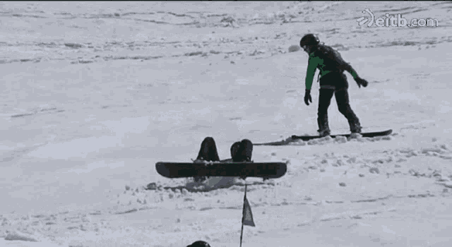 a snowboarder is falling in the snow with the website eitb.com visible in the background