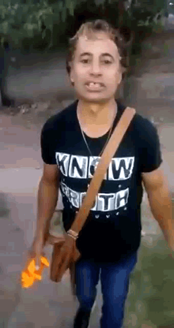 a man wearing a black t-shirt that says ' know truth '