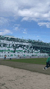 a soccer stadium with a banner that says " how long will i stay "