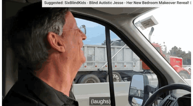 a man in a car laughs while looking out the window at a dumpster