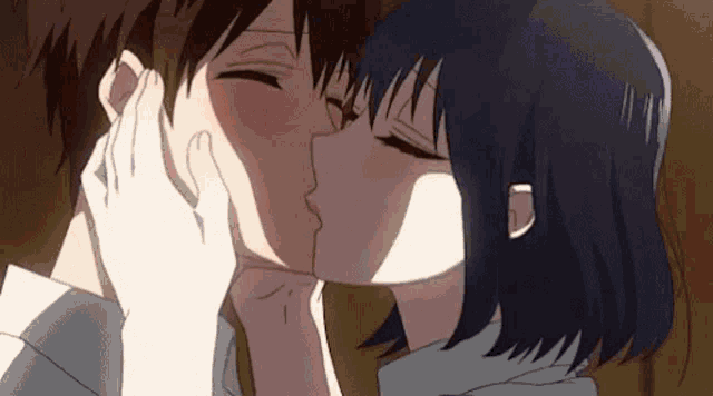 a man and a woman are kissing each other in a close up of their faces .