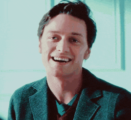 a man in a suit is smiling with his mouth open .