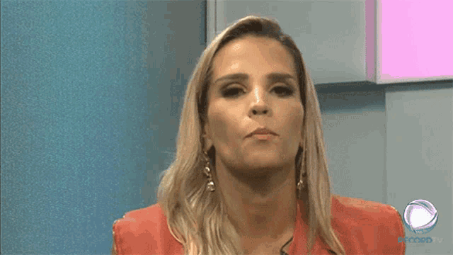a woman is making a face in front of a sign that says oicom tv