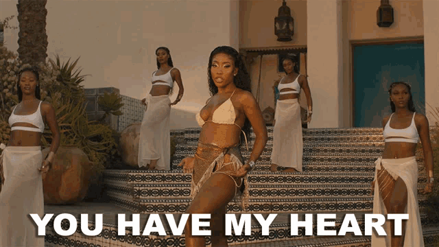 a woman in a bikini stands on a set of stairs with the words " you have my heart " above her