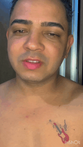 a man with a tattoo of a guitar on his chest