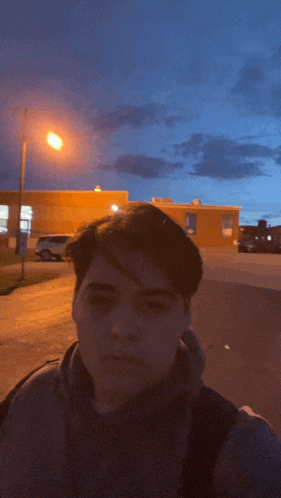 a man standing in front of a building with a street light in the foreground