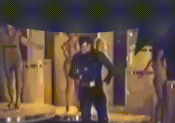 a blurry picture of a man in a police uniform standing in front of a wall .