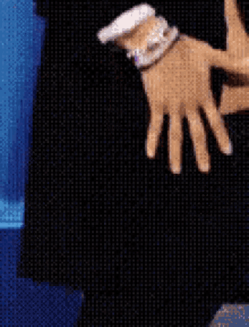 a close up of a person 's hand next to a blue bottle of lotion