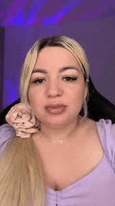 a woman with blonde hair is wearing a purple top and a purple headband .