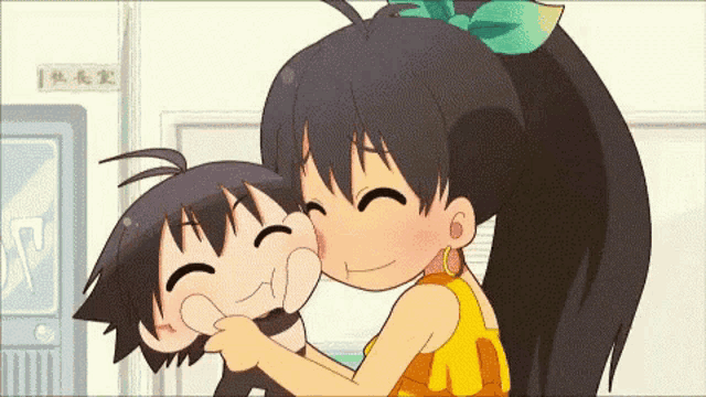 a girl is kissing a boy on the cheek in front of a sign that says ' a ' on it