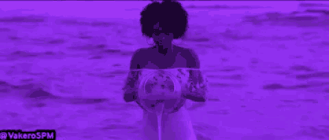 a woman in a white dress is standing in the water holding a globe .