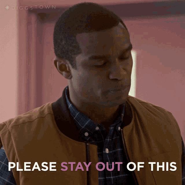a man wearing a plaid shirt and a brown vest says " please stay out of this "