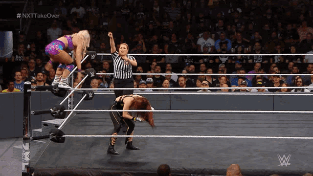 a woman in a wrestling ring with # nxttakeover written on the bottom