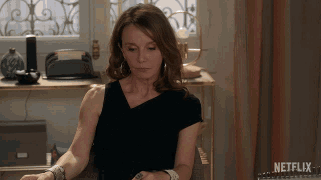a woman sits at a desk with a netflix logo in the corner