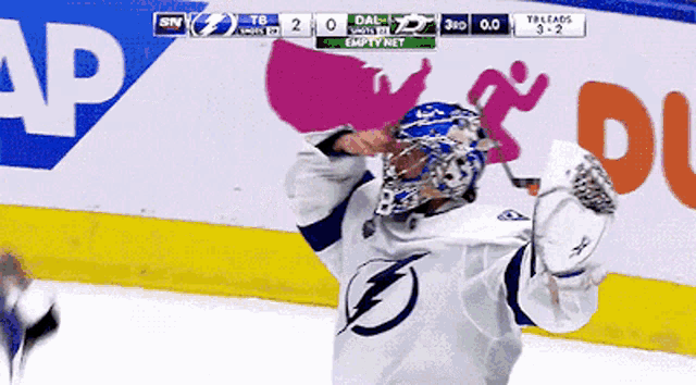 a hockey player celebrates a goal in front of an empty net