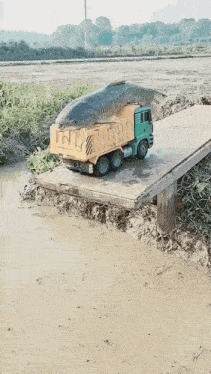 a toy dump truck is carrying a large fish on the back of it
