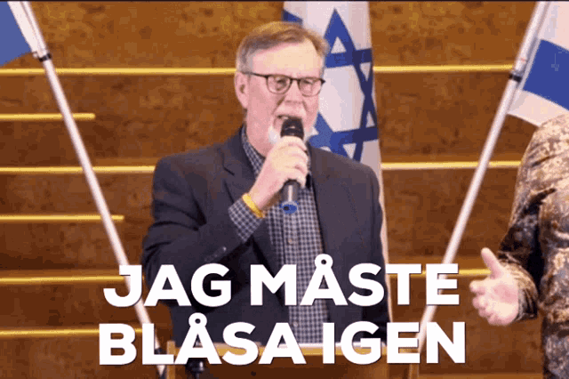 a man speaking into a microphone with the words jag maste blasa igen written below him