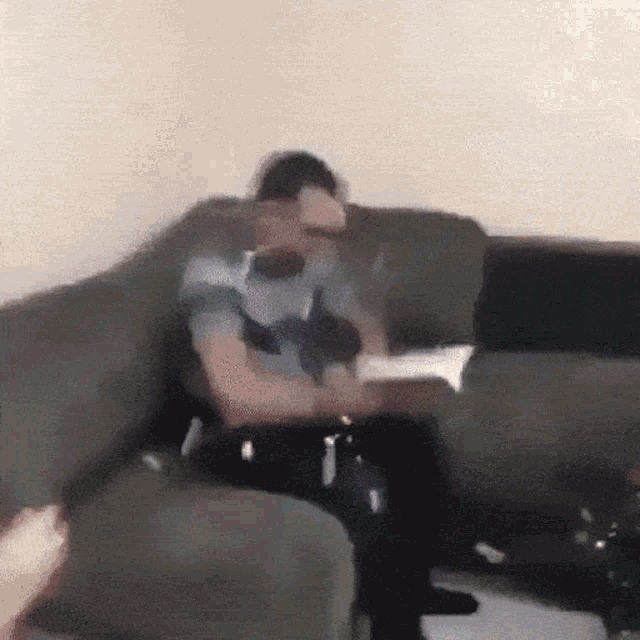 a blurry picture of a man sitting on a couch