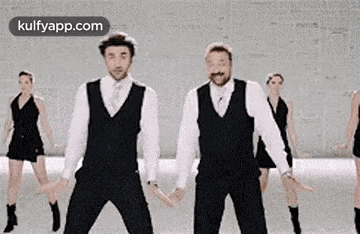 a group of men in suits and ties are dancing together in a room .
