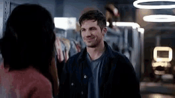 a man and a woman are standing next to each other in a store and smiling .