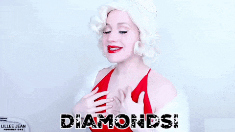 a woman in a red dress and white fur coat is holding her chest and laughing .
