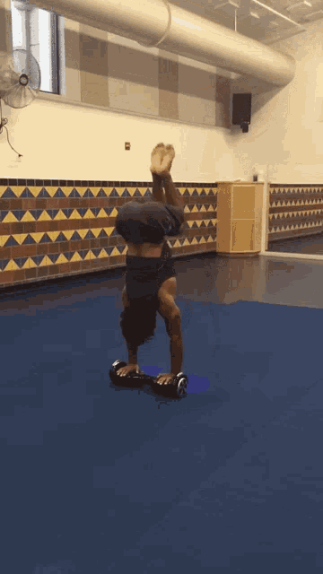 a man does a handstand on a hover board