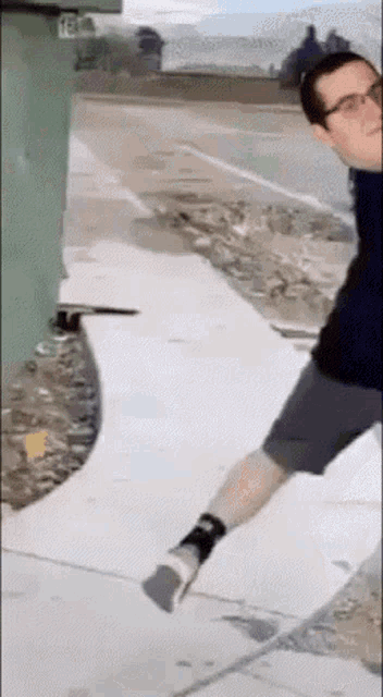 a man standing on a sidewalk with the number 18 on the side of his shirt
