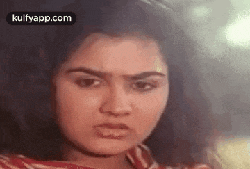 a close up of a woman 's face with a sad look on her face .