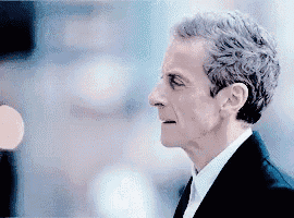 a close up of a man 's face in a suit and tie .