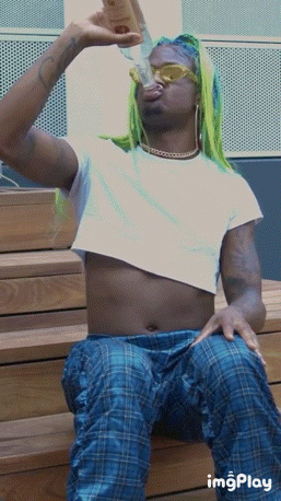 a man in a crop top drinking from a bottle