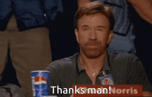 a man giving a thumbs up in front of a sign that says thanks man !