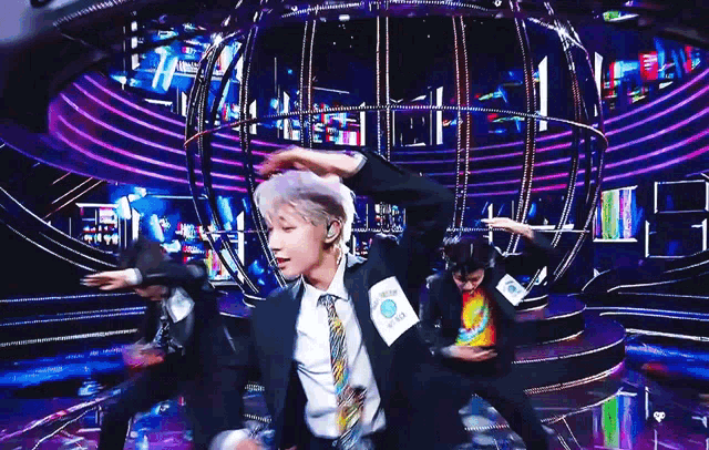 a man in a suit and tie is dancing on stage .