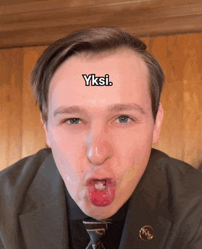 a man making a funny face with the word yksi above his head