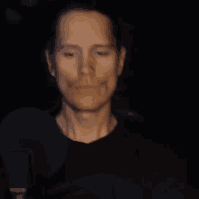a close up of a man 's face with a microphone in the background