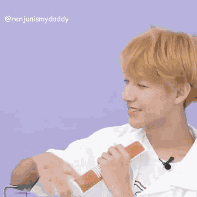 a man with blonde hair is wearing a white shirt with a heart on it