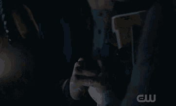 a man is sitting in a car at night looking at a cell phone .