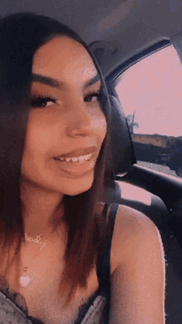a woman in a car wearing a necklace that says ' amanda ' on it