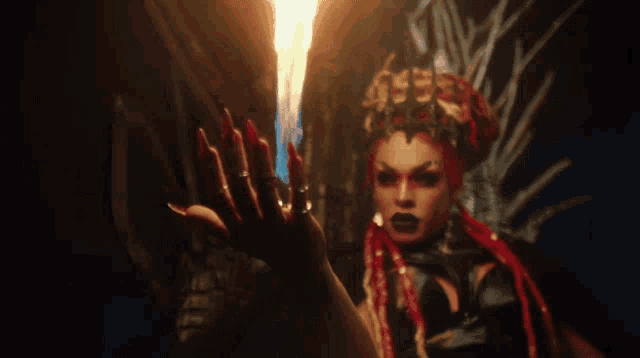 a woman with long red nails and a crown on her head