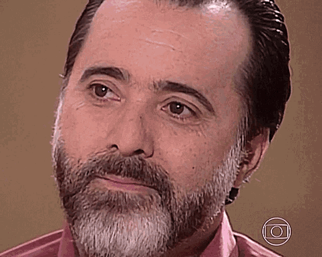 a man with a beard and a pink shirt has a circle around his face with the letter o