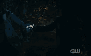 a person is standing in the dark with a cw logo in the corner .