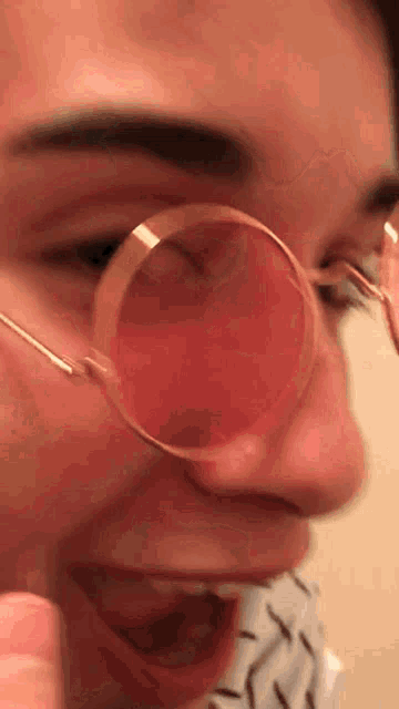 a close up of a person wearing glasses with a red lens