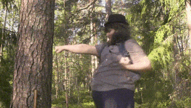 a man in a top hat is pointing at a tree