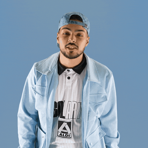 a man wearing a light blue jacket and a white shirt that says aldi