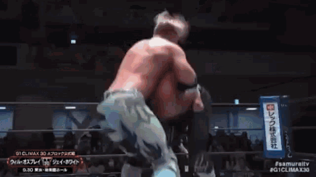 two men are wrestling in a ring and one of them is wearing a white shirt