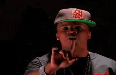 a man wearing a hat with the letter s on it is pointing his finger at the camera .