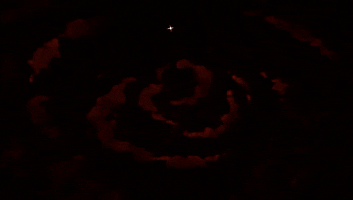 a group of people raising their hands in front of a large white circle