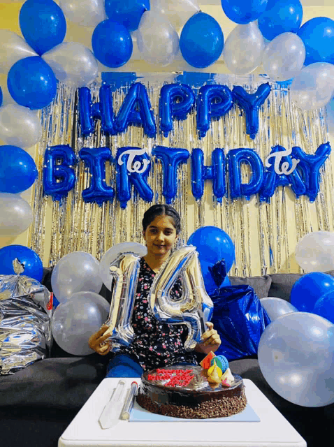 a girl celebrates her 14th birthday with balloons and cake