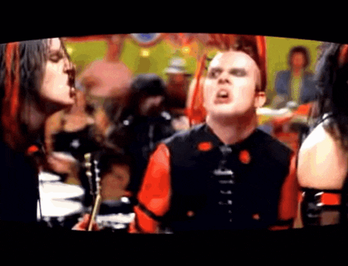 a man in a red and black outfit is standing in front of a crowd