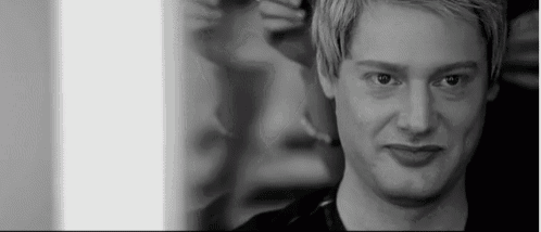a black and white photo of a man with blonde hair looking at the camera