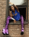 a woman is sitting on a window sill wearing purple boots